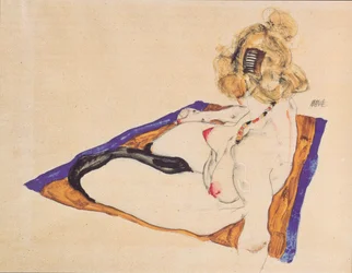 Modèle nu blond assis sur un tissu brun